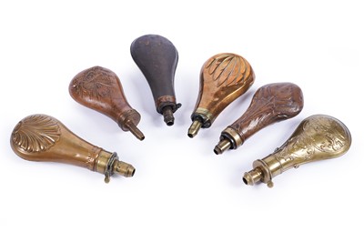 Lot 348 - Five embossed brass and copper powder flasks; and a gun metal powder flask