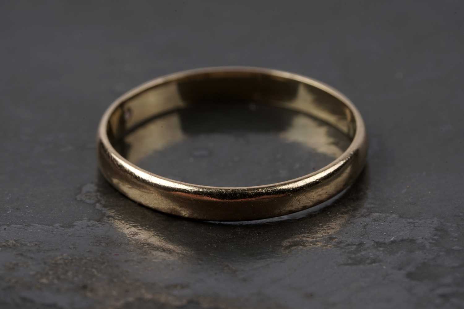 Lot 9 - An 18ct gold wedding band