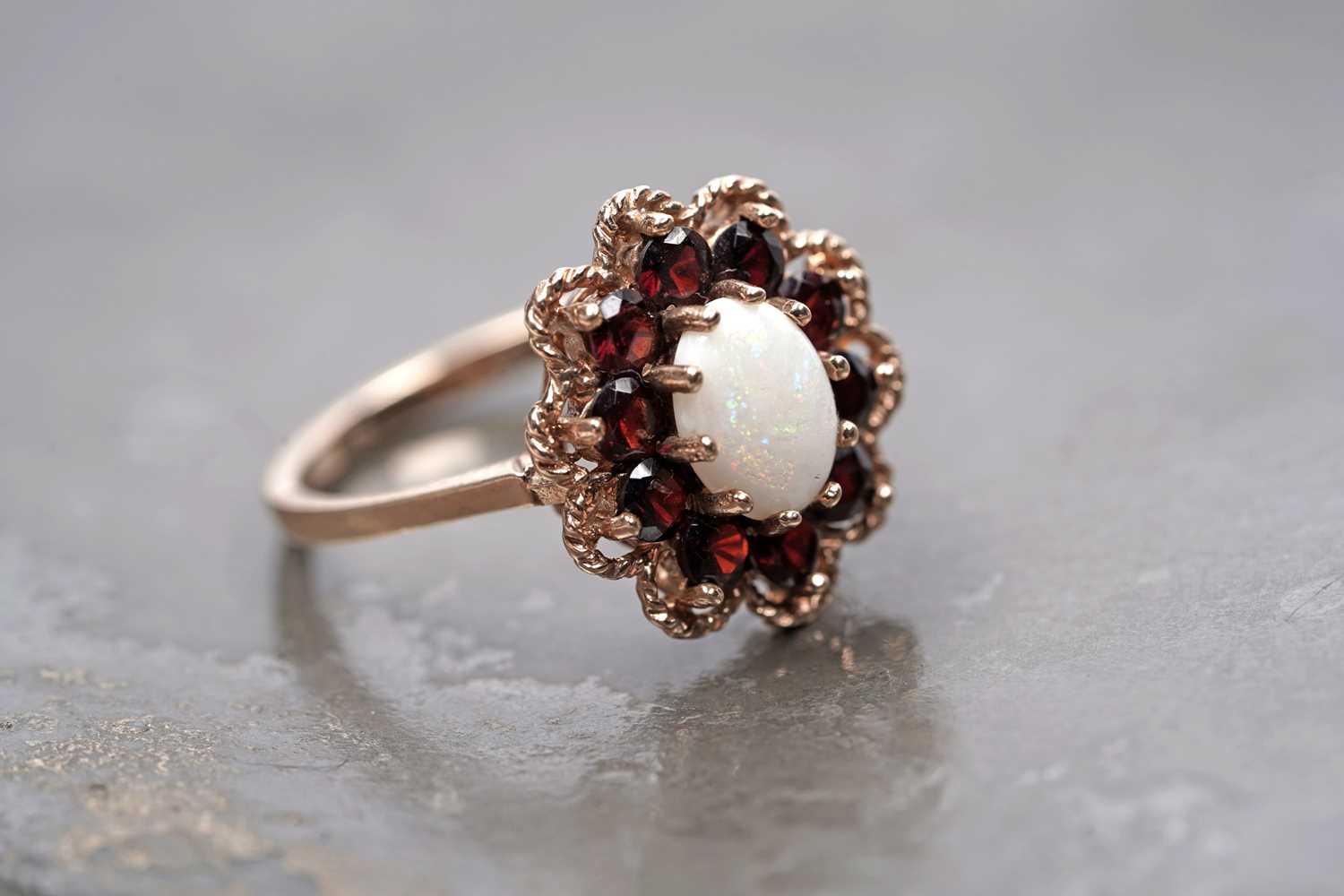 Lot 94 - A 1970s opal and garnet flower pattern dress ring