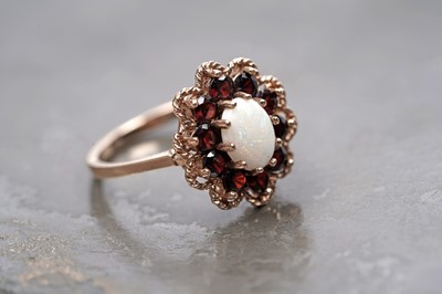 Lot 94 - A 1970s opal and garnet flower pattern dress ring