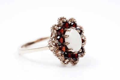 Lot 94 - A 1970s opal and garnet flower pattern dress ring