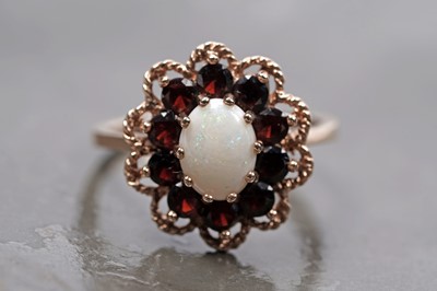 Lot 94 - A 1970s opal and garnet flower pattern dress ring
