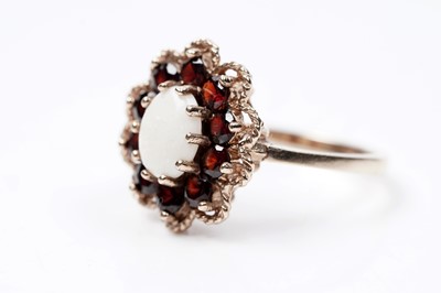 Lot 94 - A 1970s opal and garnet flower pattern dress ring