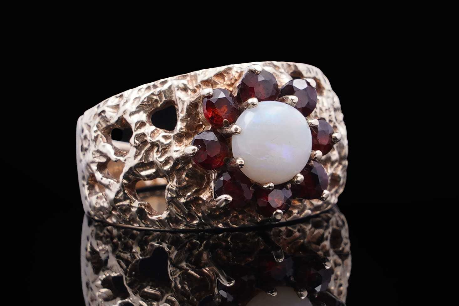 Lot 40 - A 1970s opal and garnet bark effect dress ring