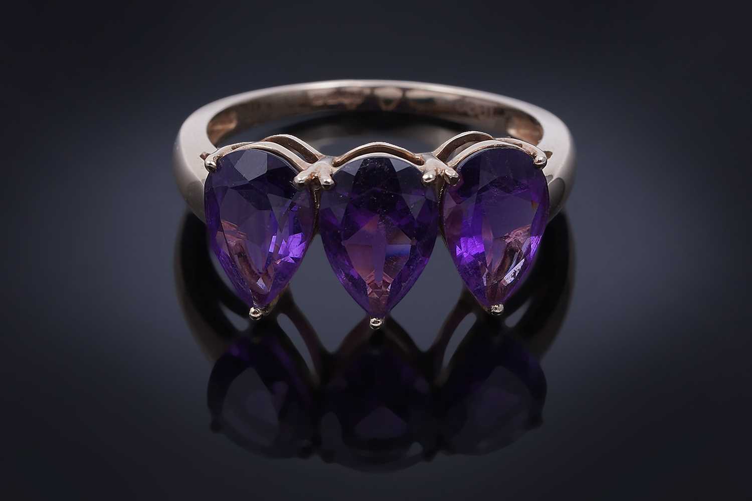 Lot 26 - A contemporary three-stone amethyst ring
