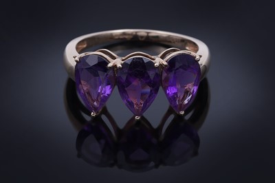 Lot 26 - A contemporary three-stone amethyst ring