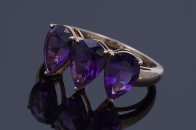 Lot 26 - A contemporary three-stone amethyst ring