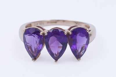 Lot 26 - A contemporary three-stone amethyst ring
