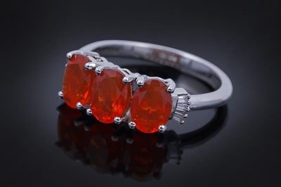Lot 30 - A contemporary Rhapsody three-stone fire opal and diamond ring