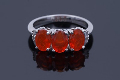 Lot 30 - A contemporary Rhapsody three-stone fire opal and diamond ring