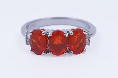Lot 30 - A contemporary Rhapsody three-stone fire opal and diamond ring