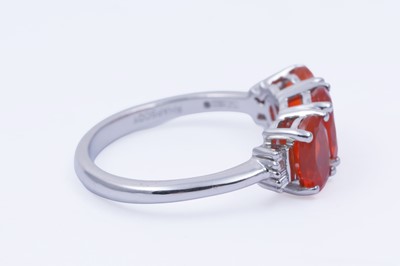 Lot 30 - A contemporary Rhapsody three-stone fire opal and diamond ring