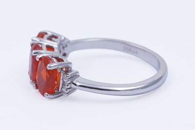 Lot 30 - A contemporary Rhapsody three-stone fire opal and diamond ring