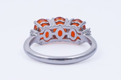 Lot 30 - A contemporary Rhapsody three-stone fire opal and diamond ring