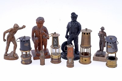 Lot 245 - Four figural studies of miners; and a selection of miniature or presentation miner’s lamps