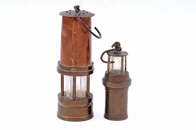 Lot 245 - Four figural studies of miners; and a selection of miniature or presentation miner’s lamps