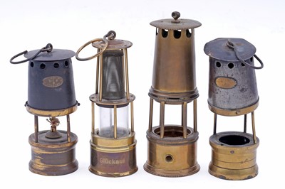 Lot 245 - Four figural studies of miners; and a selection of miniature or presentation miner’s lamps