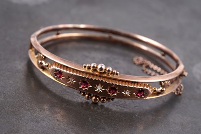 Lot 1 - An Edwardian ruby and diamond hinged bangle of Grecian influence