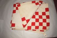 Lot 1122 - An early 20th Century Durham quilt in red and...